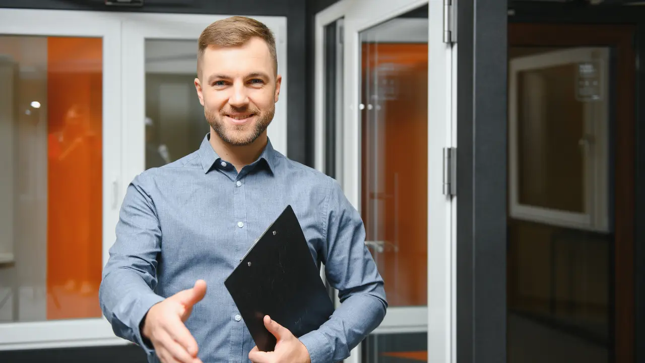 Signature d’une promesse de vente immobilière : agent immobilier tendant la main avec un dossier, illustrant l’engagement préalable entre vendeur et acheteur.